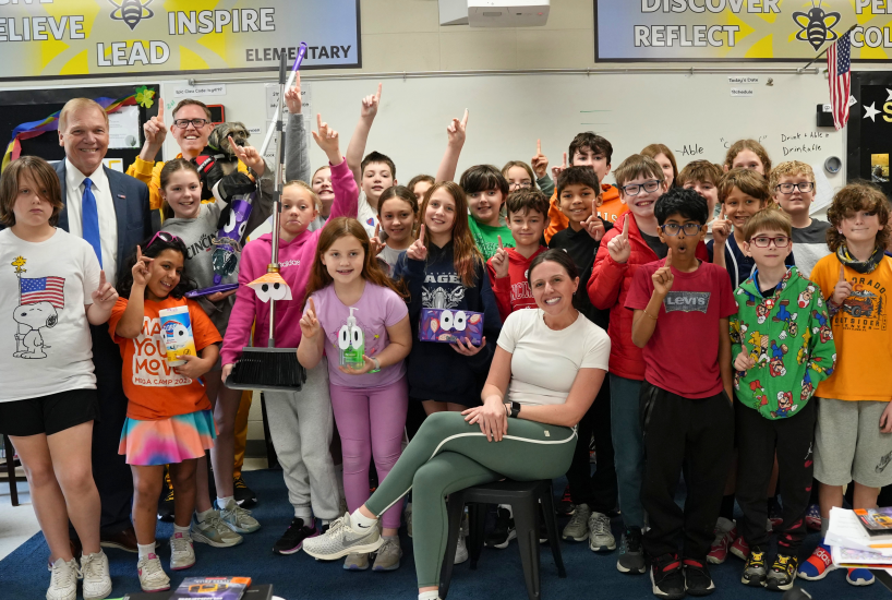students and staff pose for a class photo and hold up the number one 